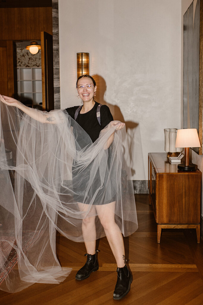 Associate photographer holding wedding veil