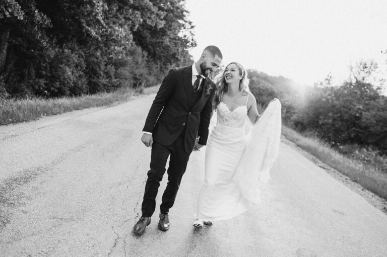 Bride and Groom running on a county backstreet near Wedding in the Woods on their wedding day