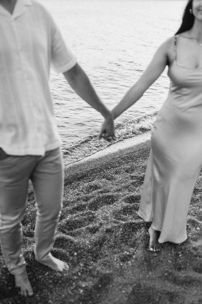 Out of focus couple on the beach with the water in focus in the background.