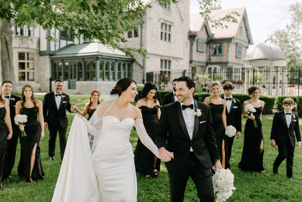 Bride and Groom walking with wedding party at Willistead Park