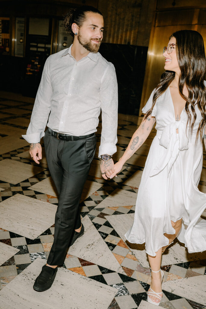 Couple walking through the Fisher building in Detroit for engagement session